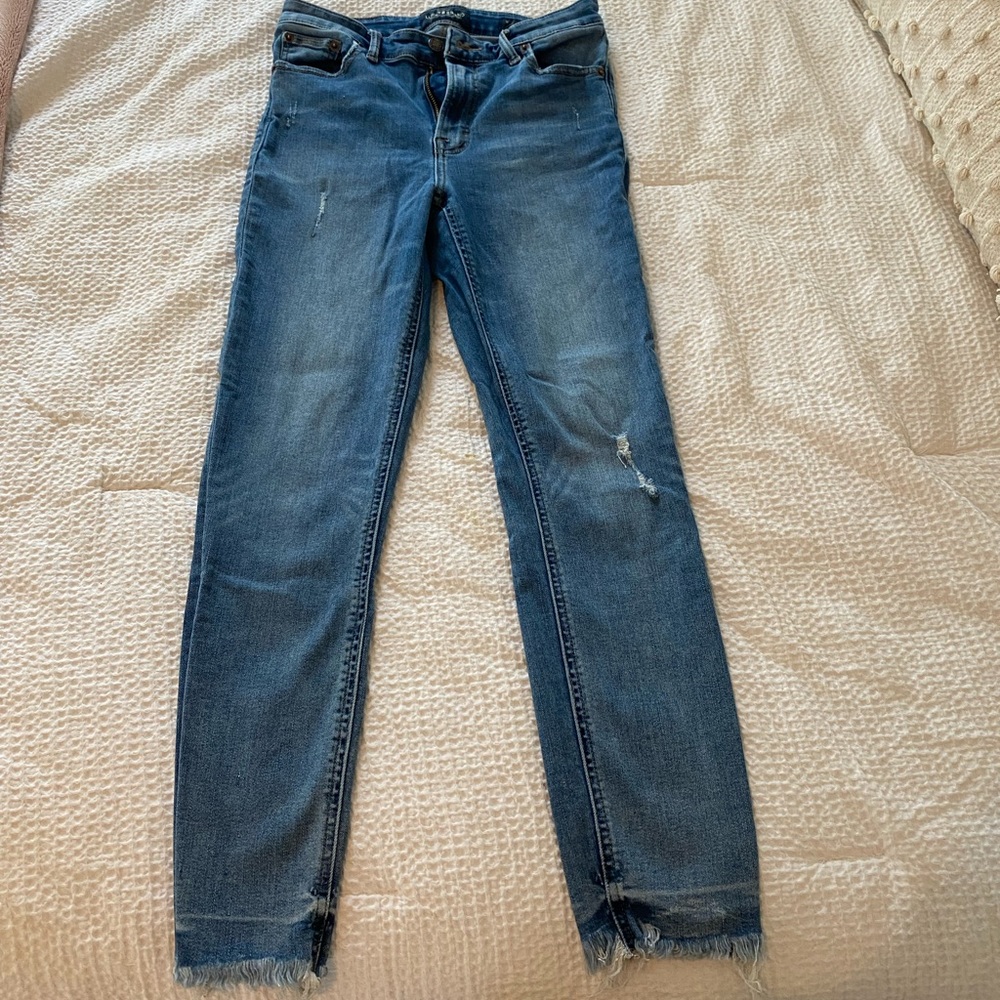 Low Rise Skinny Jeans with frailed detail on bottom.